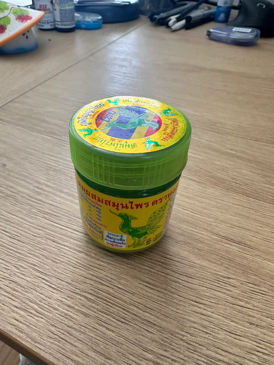A Hong Thai compound-herb inhaler — in hand, on a shelf, or back on the desk