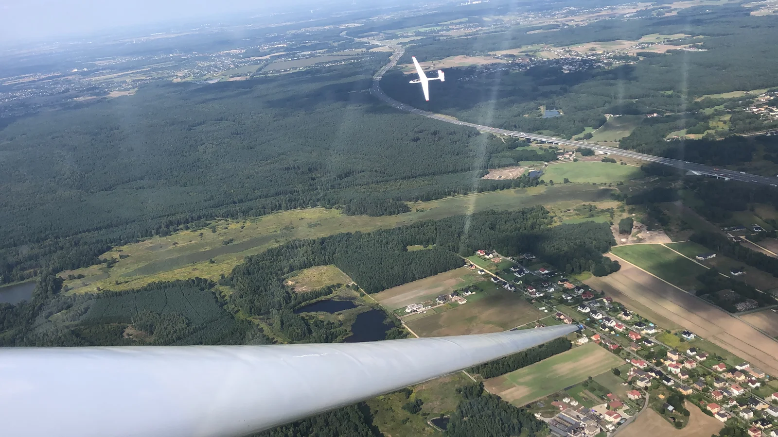 Through-the-canopy mid-flight, what the user saw — the variometer's needle on the dash, the horizon ahead.